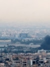 Smoke billows from a site near the Azadi Tower (L) in central Tehran, as fighting between Israel and Iran continues on June 16, 2025.