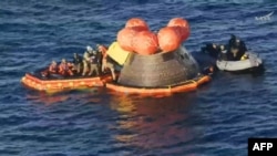 Membrii misiunii Artemis II (îmbrăcați în costume portocalii) sunt evacuați din nava spațială după amerizarea în Oceanul Pacific, în largul coastei orașului San Diego, California, pe 10 aprilie 2026.