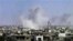 Smoke rises following purported shelling in Homs on April 10.