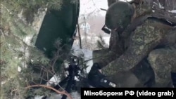 Російський військовий розкладає обладнання для зв'язку