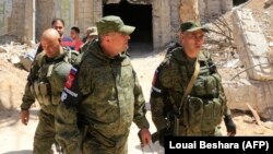 Russian forces patrol damaged buildings in Douma on the outskirts of Damascus.