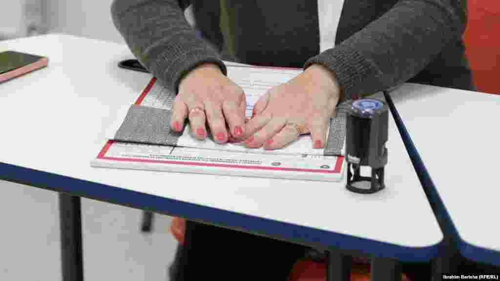 Një zyrtare zgjedhore palos një fletëvotim në zgjedhjet e parakohshme parlamentare në një qendër votimi në Prishtinë.