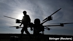 Ukrainian soldiers walk next to a heavy strike drone at a training ground in the Zaporizhzhya region in March.