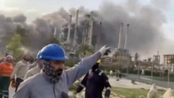Workers evacuate the area around Saudi Aramco's Ras Tanura oil refinery as smoke rises following a reported Iranian drone strike on March 2.