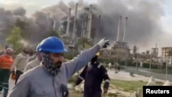 Работници се евакуриат на фона на дима в рафинерията Рас Танура на "Арамко", в Саудитска Арабия, 2 март 2026 г.