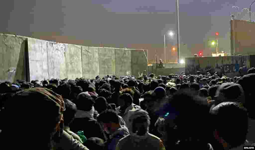 People struggle to get into Hamid Karzai International Airport in the hope of fleeing the country on the night of August 23.