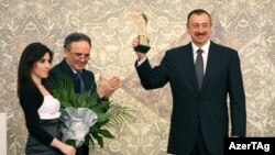 Azerbaijani President Ilham Aliyev holds his "Friend of Journalists" Award aloft at a ceremony in Baku on December 29.