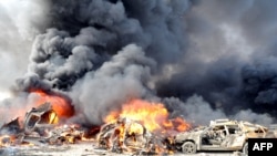 Smoke rises from burning cars at the site of the twin blasts in Damascus on May 10.