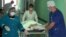 Medics pull a trolley with 18-year-old Oksana Makar, who was raped, strangled, and burned alive, in a hospital in the city of Donetsk on March 19.