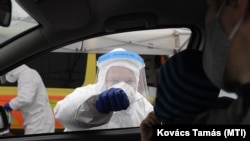  Mintát vesznek egy autóval érkező pácienstől a koronavírus-gyanús esetek szűrésére felállított mobil mintavételező állomáson Szentendrén. MTI/Kovács Tamás, Szentendre, 2020. december 16. 