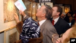 French ambassador to Tehran, Francois Nicoullaud, center, points to a map as he tours an exhibition of historical maps unveiled by the Iranian Foreign Ministry to prove the legitimacy of calling the strategic sea the "Persian Gulf", a reaction to the use 