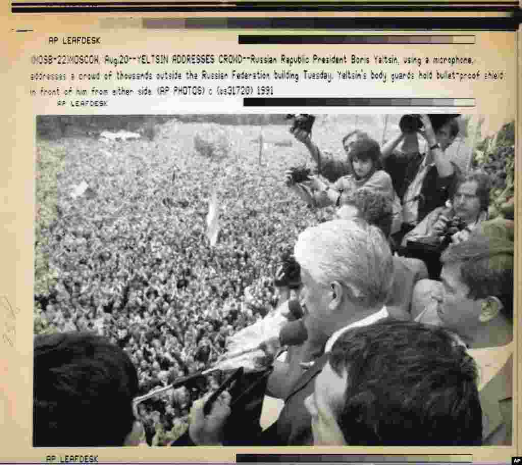 Yeltsin uses a microphone to address thousands of supporters gathered outside the Russian parliament building on August 20.&nbsp; &nbsp; 