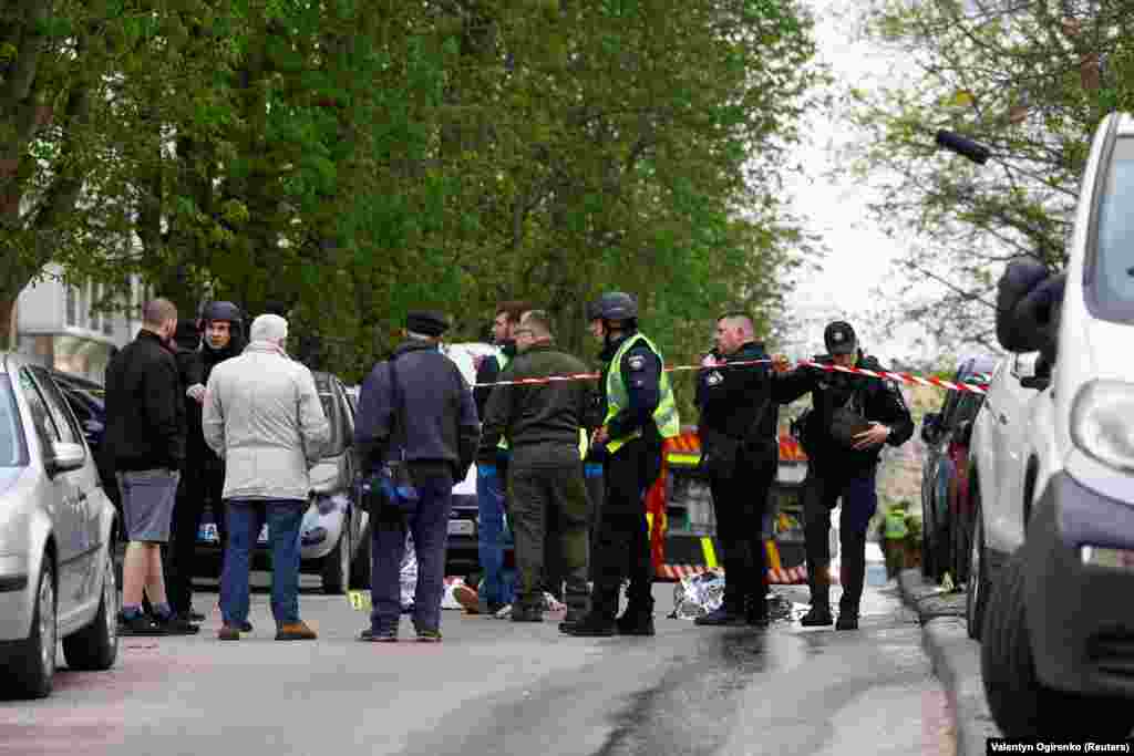 Полицейские стоят рядом с телами на месте стрельбы в Киеве, Украина, 18 апреля 2026 года. REUTERS/Валентин Огиренко