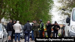 Поліцейські стоять поруч із тілами на місці стрілянини в Києві, Україна, 18 квітня 2026 року