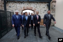 Міністар замежных спраў Украіны Андрэй Сыбіга, дзяржаўны сакратар ЗША Марка Рубіё, міністар замежных справаў Турэччыны Хакан Фідан і кіраўнік Офісу прэзыдэнта Украіны Андрэй Ярмак прыбылі на сустрэчу ў палац Далмабахчэ ў Стамбуле. 16 траўня 2025 году