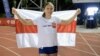 Krystsina Tsimanouskaya poses for a picture with a red and white flag, which is a symbol of the opposition movement in Belarus, during a competition at a stadium in Szczec, Poland, in August 2021.