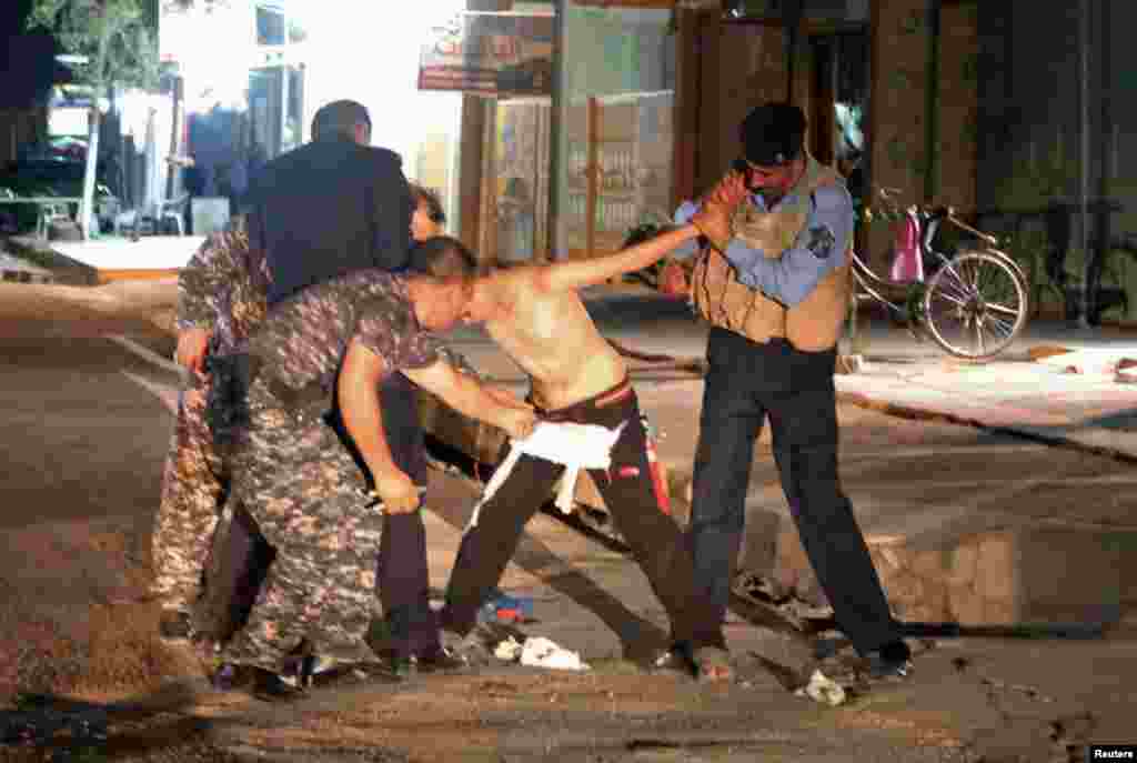 Iraqi security forces are seen removing an explosives vest from a would-be suicide bomber -- a young boy -- in Kirkuk. The boy was apprehended late on August 21 shortly after a suicide bomb attack on a Shi'ite mosque in the city. "The boy claimed during interrogation that he had been kidnapped by masked men who put the explosives on him and sent him to the area," Kirkuk intelligence official Chato Fadhil Humadi told AP. (Reuters/Ako Rasheed)