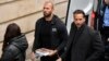 Andrew Tate (center) and his brother, Tristan (right), are brought by police officers to an appeals court in Bucharest on January 10. 
