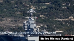 جنگنده‌ها بر روی عرشه ناو «یواس‌اس جرالد آر. فورد» در بندری در جزیره کرت یونان، پنجم اسفند.<br><br>واشینگتن در حال حاضر یکی از بزرگ‌ترین آرایش‌های نظامی خود را در خاورمیانه از زمان حمله سال ۲۰۰۳ به عراق صورت می‌دهد.