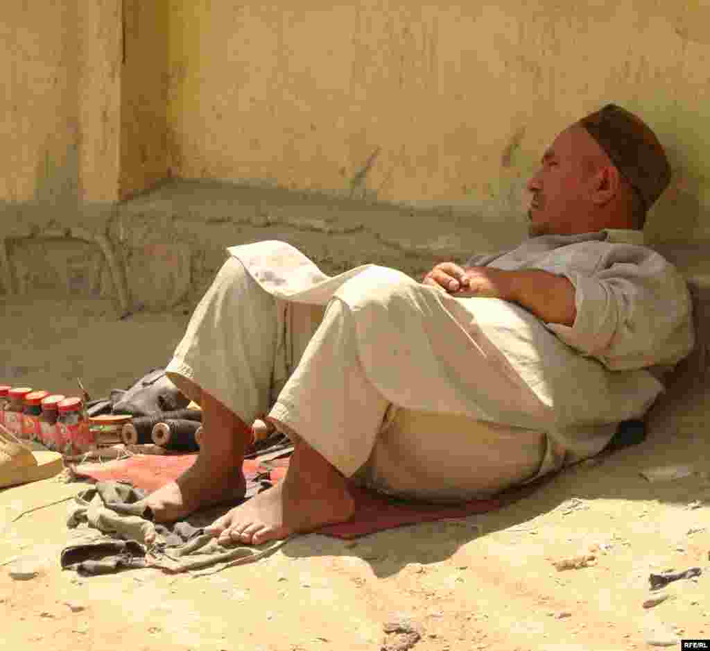 Čekajući mušterije - Avganistan - Čovek sedi pored puta čekajući mušterije kako bi im očistio cipele