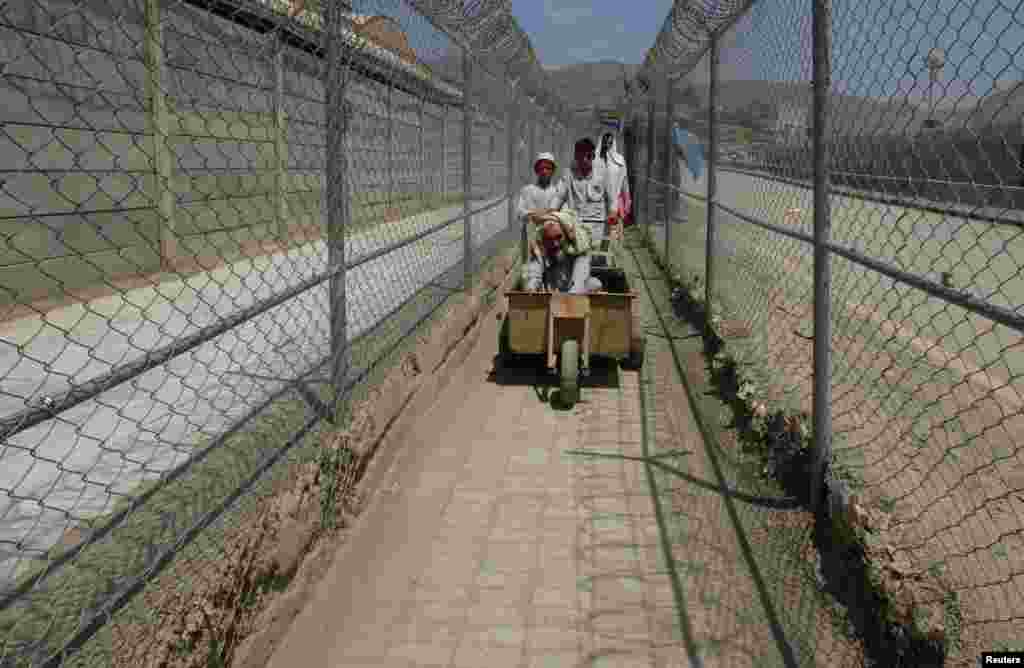 Men coming from Afghanistan move down a corridor between security fences at border crossing with neighboring Pakistan in Torkham. (Reuters/Fayaz Aziz)