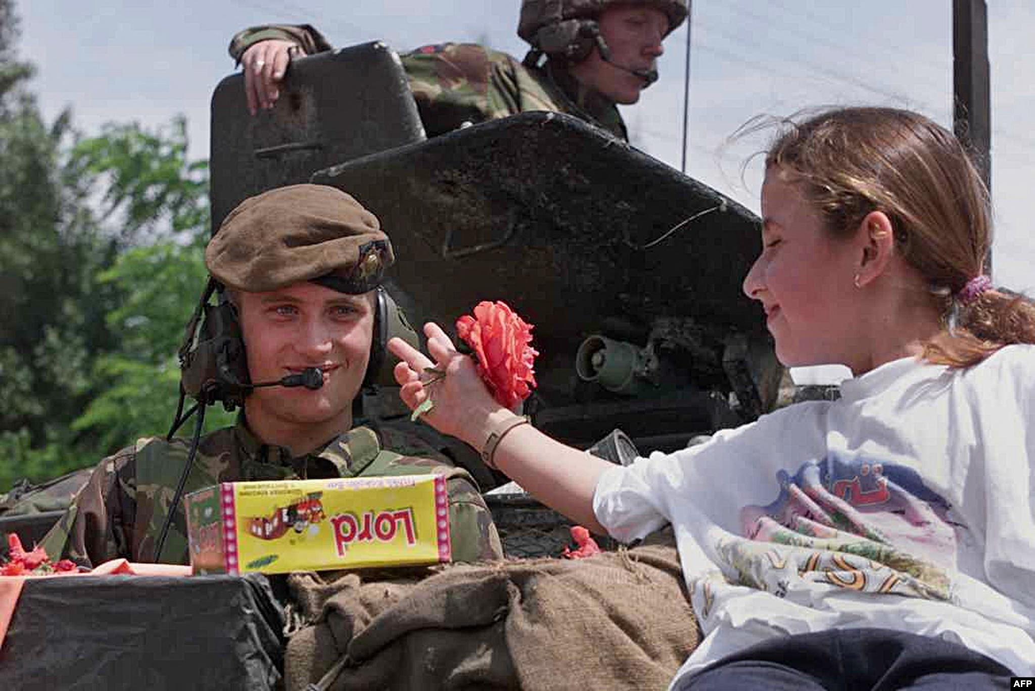 Një vajzë i jep një lule një ushtari britanik në Prishtinë më 13 qershor 1999.