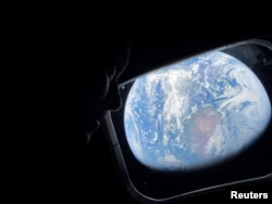 Astronautul NASA și comandantul misiunii Artemis II, Reid Wiseman, privește pe una dintre ferestrele cabinei principale ale navei Orion.