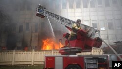 Рятувальники гасять пожежу після влучання ракети в Харкові, 20 березня 2024 року