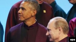 China -- Russian President Vladimir Putin (R) walks past US President Barack Obama before taking a family photo during the APEC summit 2014 in Beijing, November 10, 2014