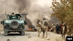 Afghan security officials secure the scene of a suicide bomb blast that targeted the office of a local attorney general in Kunduz on 27 October 2014.