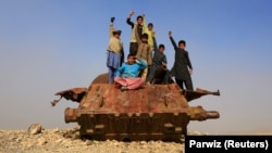 Afghan children play on Soviet-era wreckage on the outskirts of Jalalabad.