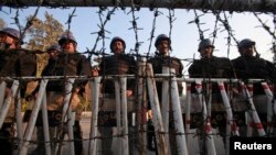 Olițiști pakistanezi blocînd un drum spre Consulatul american de la Islamabad