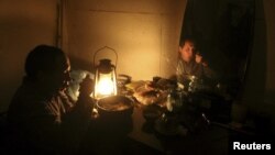 Қырымда білте шам жарығымен кешкі ас ішіп отырған адам. (Көрнекі сурет.)