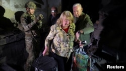 Mayor Ihor Terekhov assists a resident during an evacuation from an apartment building that was hit by a Russian air strike in Kharkiv on September 22.