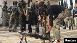 Free Syrian Army fighters prepare their weapons near the town of Atareb.