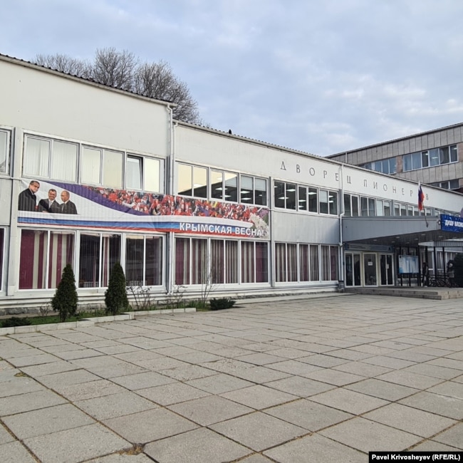 Банер на фасаді Палацу піонерів у Сімферополі, присвячений російській анексії Криму. Березень 2026 року