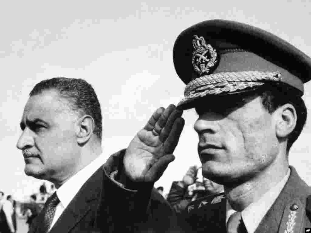 In this 1969 file photo, Qaddafi salutes as he appears with Egypt's Prime Minister Gamal Abdel Nasser, in Suez, Egypt.