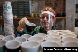 Egy belgrádi kávézó baristája védőfelszerelésben. A jövőben már más ízű kávét szolgálhat fel?