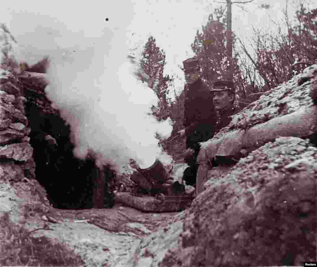 An undated photo shows French soldiers firing a 155 mm mortar from a trench on the front line, at an unknown location in France.