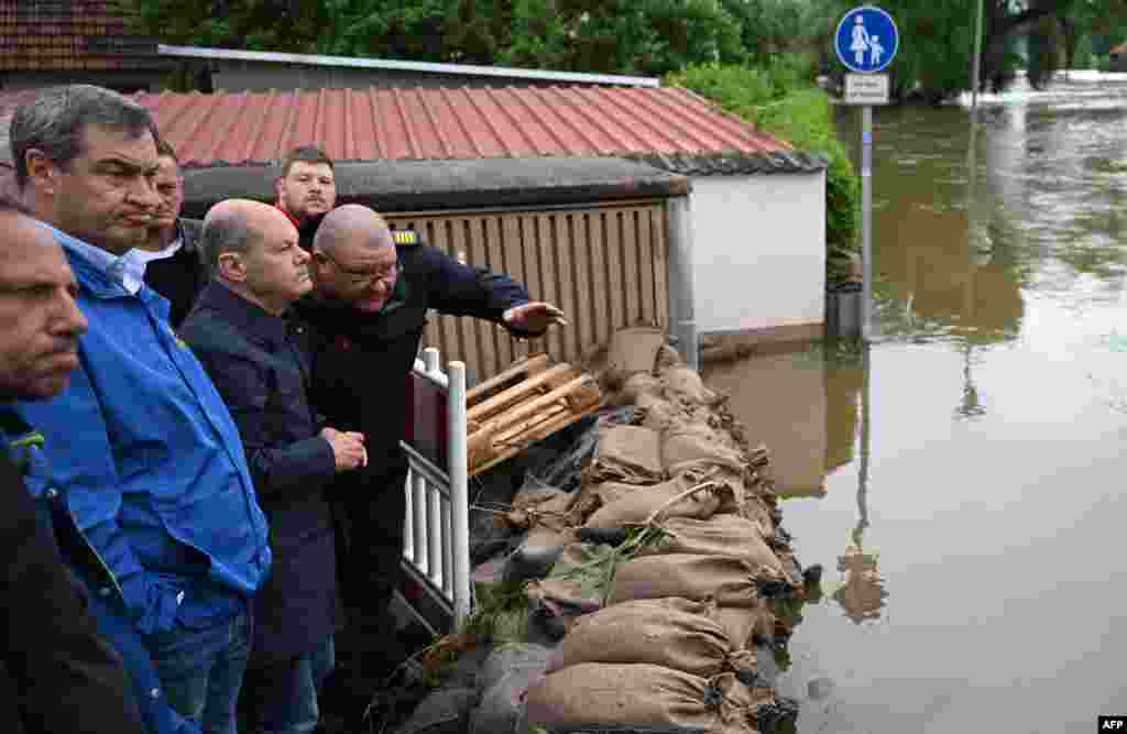 Cancelarul Olaf Scholz a vizitat luni, 3 iunie, unul din orașele bavareze cel mai greu lovite de inundații, Reichertshofen, spunând că avem de-a face cu o nouă manifestare extremă a schimbărilor climaterice, pe care nu avem dreptul să le neglijăm. Premierul bavarez, Markus Soeder (în bluză albastră), a spus la rândul lui: &bdquo;Sunt lucruri care nu s-au mai întâmplat niciodată&rdquo;.&nbsp;