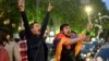 ARMENIA -- A man covered with a national flag waves an opened bottle of a sparkling wine celebrating Armenian Prime Minister's Serzh Sarkisian's resignation in Republic Square in Yerevan, April 23, 2018