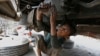 Sami Ullah (10) radi u automehaničarskoj radionici da bi zaradio za život svoje porodicu u Lahoreu u Pakistanu.