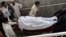 Pakistani paramedics move the body of a female polio-vaccination worker to a hospital following a deadly attack by gunmen in Peshawar on May 28. 