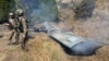 Pakistani soldiers stand next to what Pakistan says is the wreckage of an Indian fighter jet shot down in Pakistan controled Kashmir at Somani area in Bhimbar district near the Line of Control on February 27, 2019. - Pakistan said on February 27 it shot d