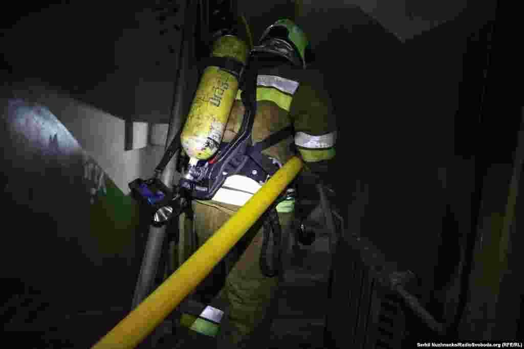 Рятувальник пересувається будинком, у якому триває евакуація людей