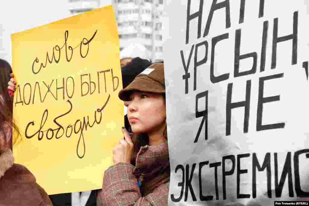 A protester (left) holding a sign demanding free speech.