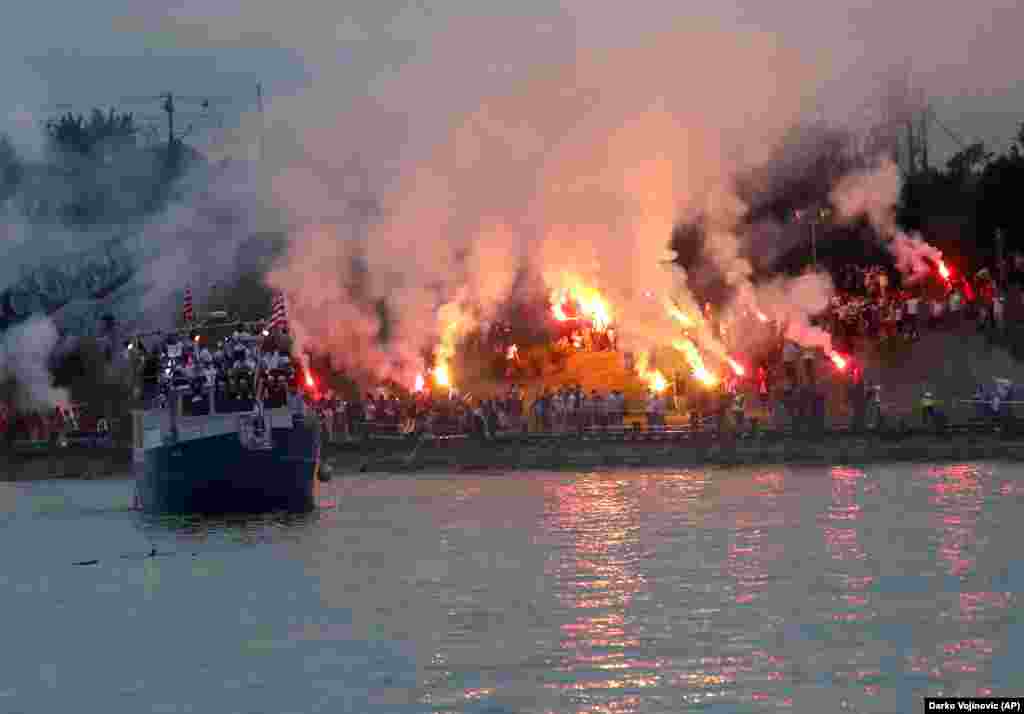 A boat carrying Red Star Belgrade&#39;s players cruises on the Sava River as fans of the club celebrate their team winning the Serbian soccer league title in the capital on May 22. Several people were injured and more than 100 arrested after violent clashes during the boisterous celebrations.