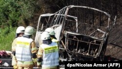 نمایی از اتوبوس آتش گرفته که تنها اسکلت فلزی آن باقی مانده است.