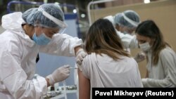Медработник ставит прививку посетителю в пункте вакцинации. Алматы, 2 апреля 2021 года.