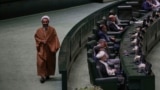 An Iranian cleric lawmaker walks at the parliament during a memorial, in Tehran, Iran, Wednesday, May 21, 2025